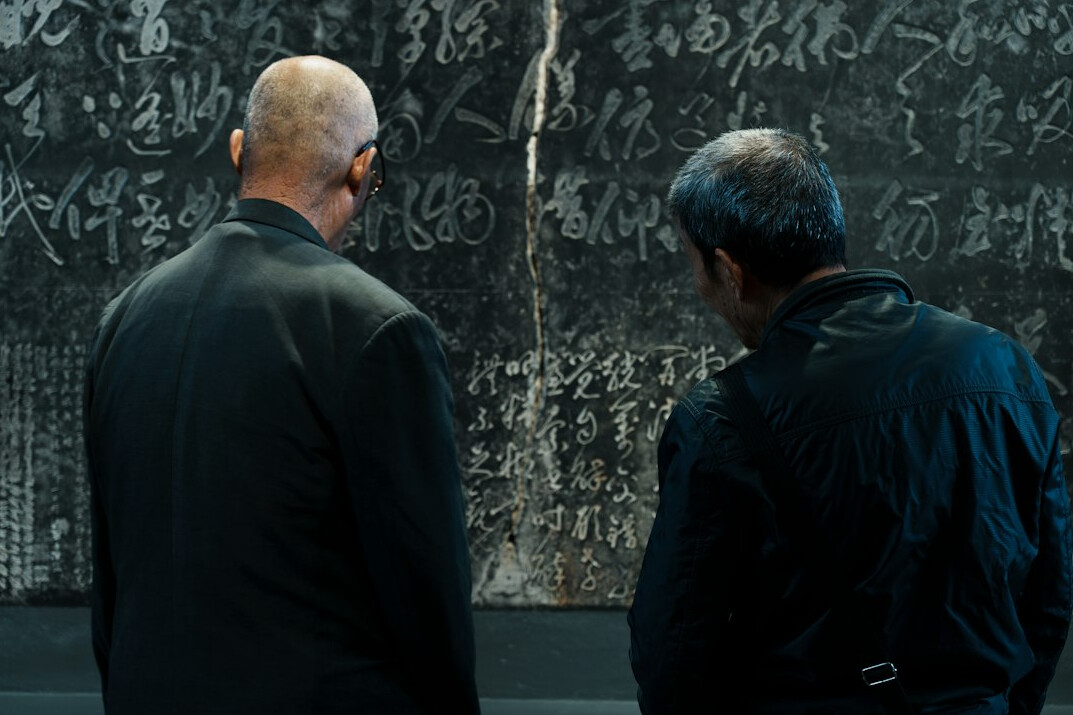 Small editorial team reviewing evidence on a whiteboard